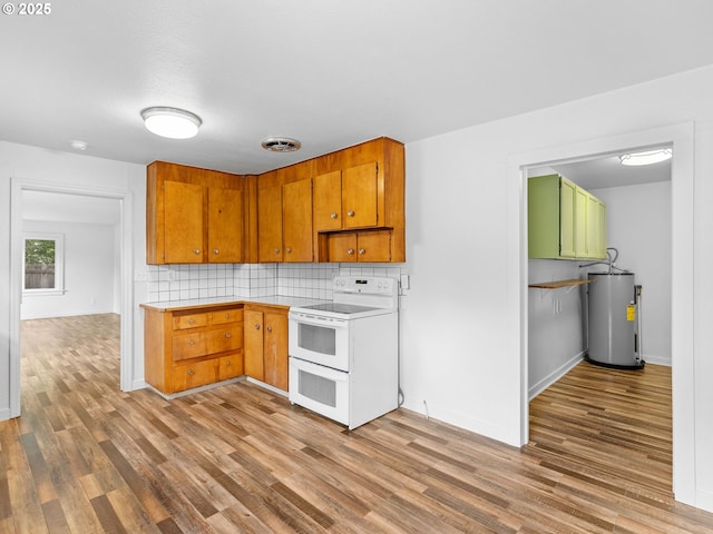 2745 SW 187th Ave, Beaverton, OR 97003 - kitchen with white range with electric stovetop, water heater, wood finished floors, tasteful backsplash, and light countertops
