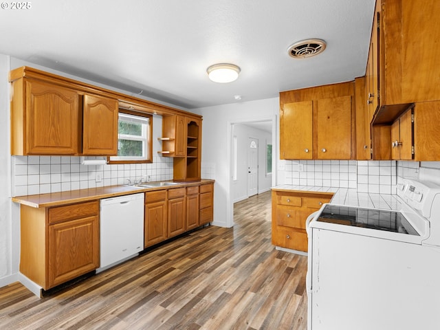 2745 SW 187th Ave, Beaverton, OR 97003 - kitchen with white appliances, backsplash, light wood-style floors, and brown cabinets