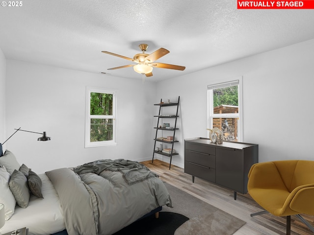 2745 SW 187th Ave, Beaverton, OR 97003 - bedroom featuring light wood-style flooring, a textured ceiling, and ceiling fan