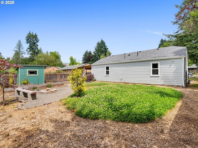 2745 SW 187th Ave, Beaverton, OR 97003 - back of house with a vegetable garden, a shingled roof, and a storage unit