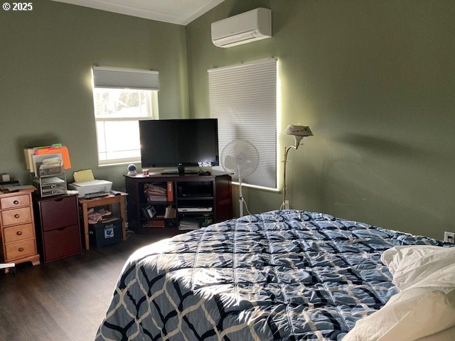 bedroom with dark hardwood / wood-style floors, vaulted ceiling, a wall mounted AC, and crown molding