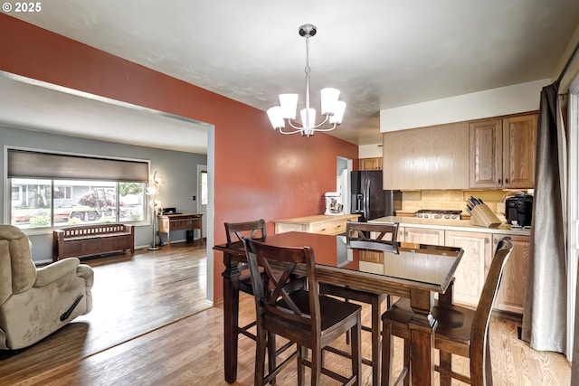 dining area featuring an inviting chandelier and light wood-type flooring