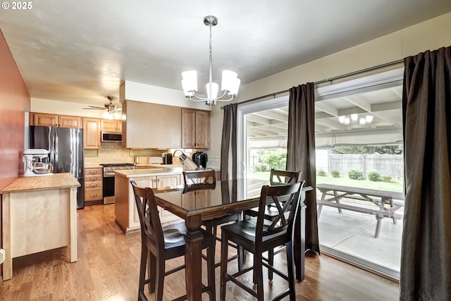 dining area featuring light wood finished floors and a notable chandelier