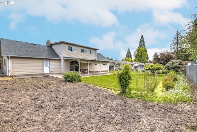 back of property featuring fence, roof with shingles, a chimney, a patio area, and a lawn