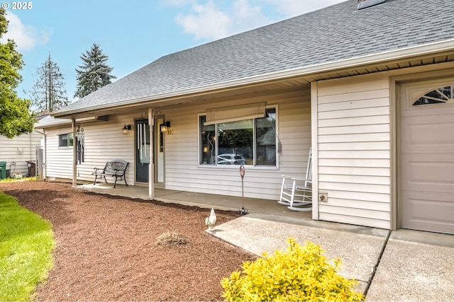 exterior space featuring covered porch, a shingled roof, and an attached garage