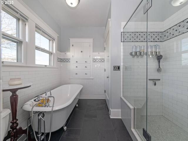 bathroom with tile patterned flooring, tile walls, and plus walk in shower