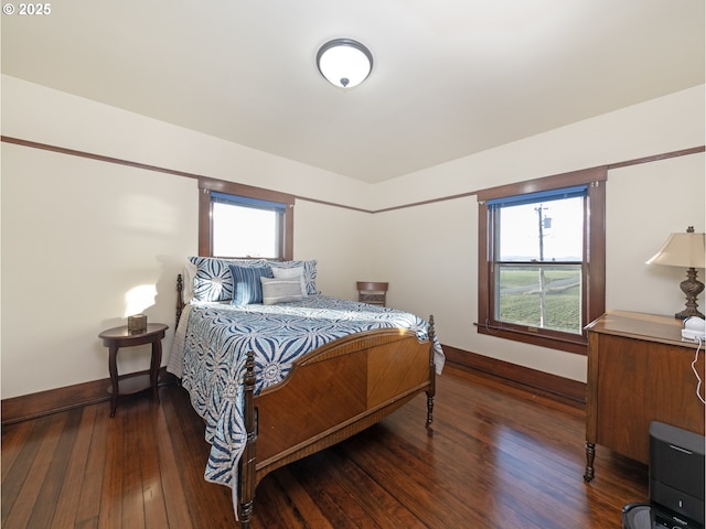 bedroom with dark wood-type flooring and multiple windows