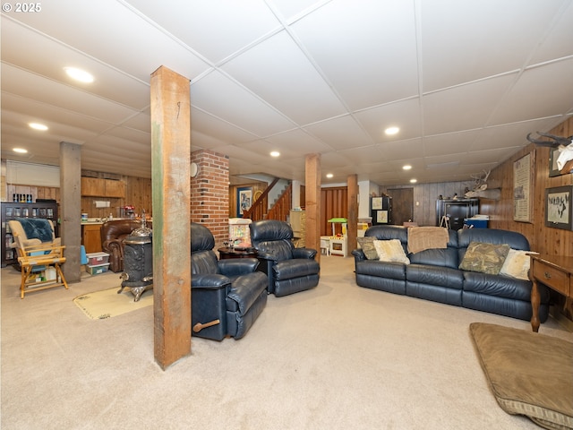 carpeted living room featuring wood walls