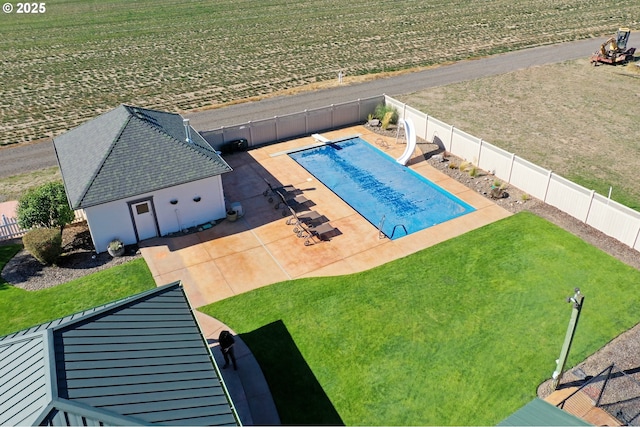 view of pool featuring a lawn, a water slide, a diving board, and a patio