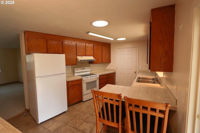 kitchen featuring sink, white appliances, tile countertops, and light tile patterned floors