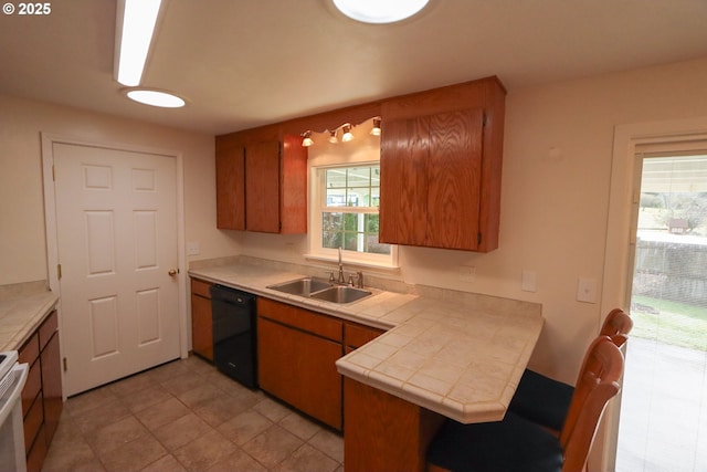 kitchen with white range with electric stovetop, black dishwasher, sink, tile counters, and kitchen peninsula