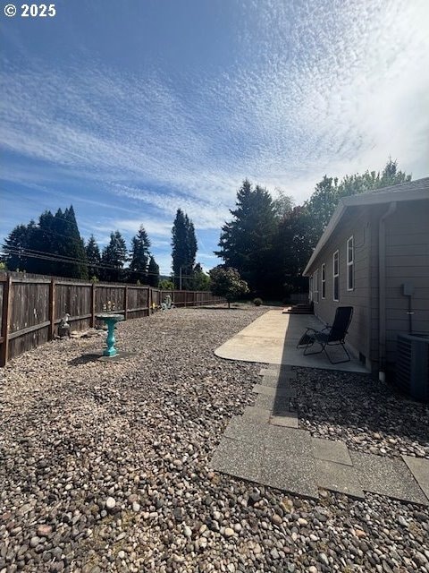 99 Rainbow Way, Kelso, WA 98626 - fenced backyard with a patio and central AC unit