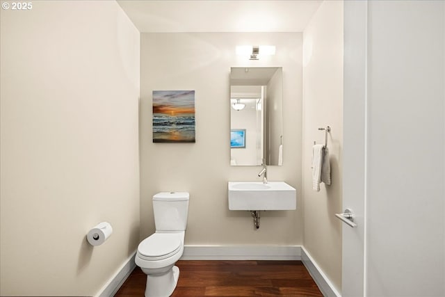 311 NW 12th Ave Unit 602, Portland, OR 97209 - bathroom featuring wood finished floors, toilet, and baseboards