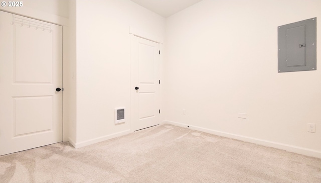 spare room featuring electric panel and light colored carpet