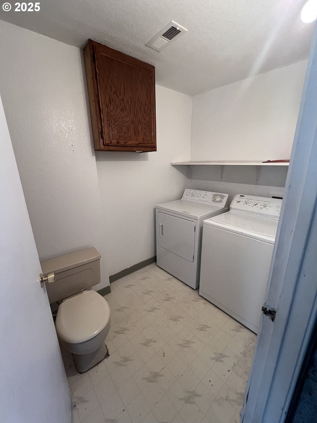 laundry room featuring laundry area, a textured ceiling, visible vents, washing machine and dryer, and light floors