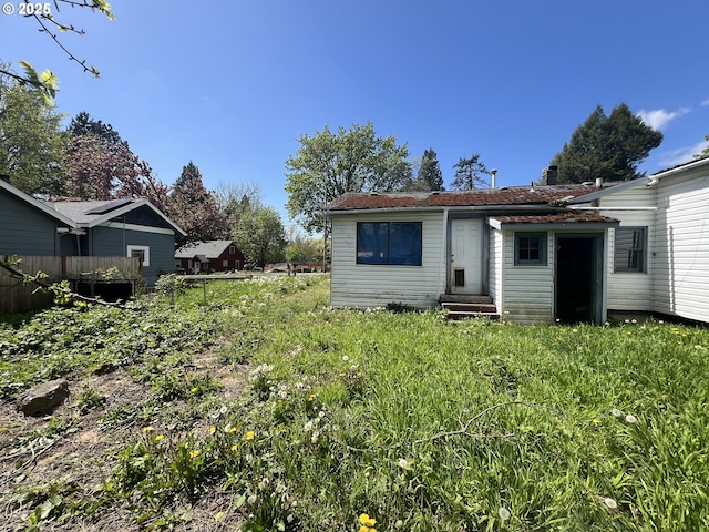back of property featuring fence and entry steps