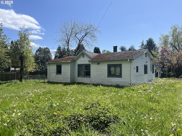 back of property with fence and a chimney