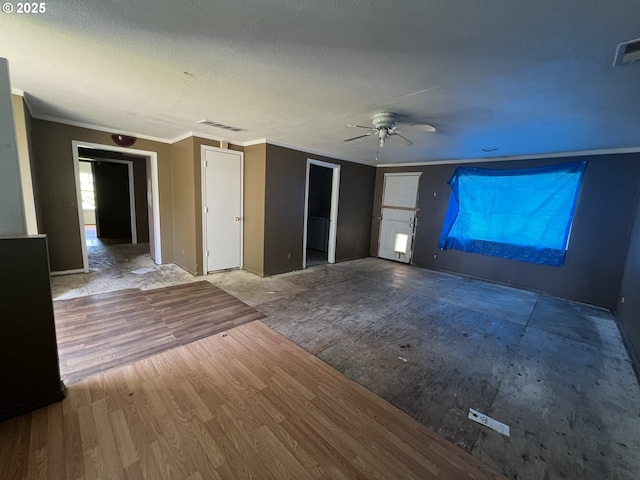 unfurnished living room with crown molding, baseboards, a ceiling fan, and visible vents