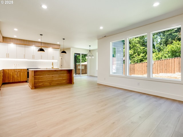 5412 NE 111th St, Vancouver, WA 98686 - kitchen with recessed lighting, decorative backsplash, light countertops, light wood finished floors, and an island with sink