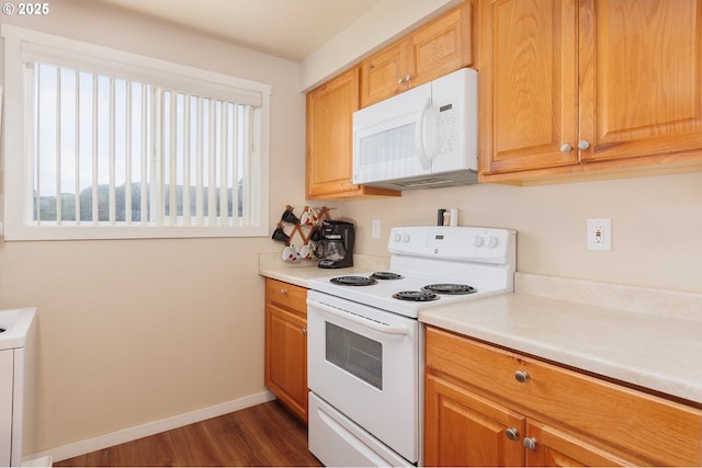 kitchen with washer / clothes dryer, dark hardwood / wood-style floors, and white appliances