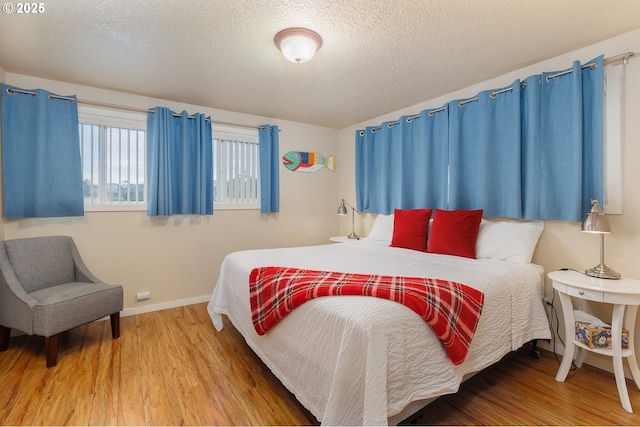 bedroom with wood-type flooring and a textured ceiling