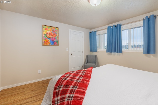 bedroom featuring wood-type flooring and a textured ceiling