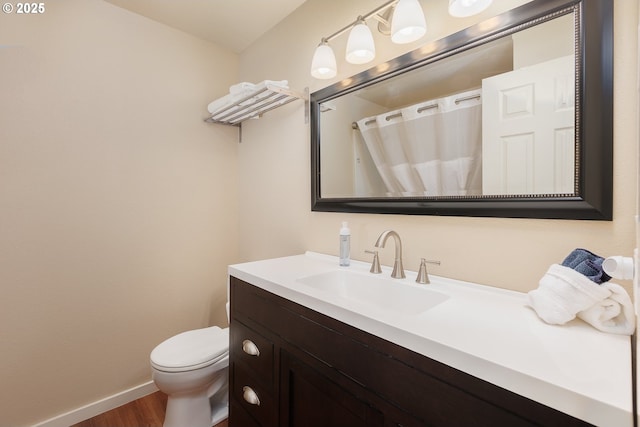 bathroom featuring toilet, hardwood / wood-style floors, and vanity