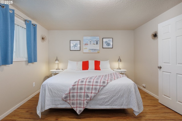 bedroom featuring a textured ceiling and hardwood / wood-style flooring