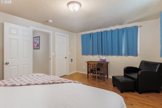 bedroom featuring wood-type flooring and a textured ceiling