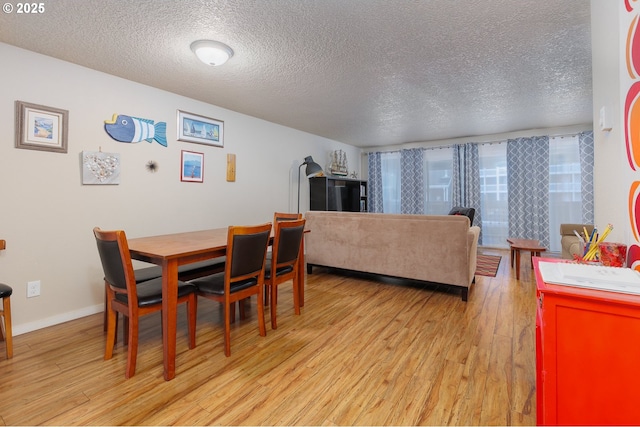 dining space featuring a textured ceiling and light hardwood / wood-style floors