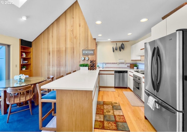 2036 NE Lagoon Ln, Lincoln City, OR 97367 - kitchen with appliances with stainless steel finishes, a peninsula, light countertops, a sink, and white cabinets