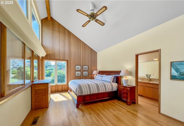 2036 NE Lagoon Ln, Lincoln City, OR 97367 - bedroom featuring high vaulted ceiling, light wood-style flooring, beam ceiling, ensuite bath, and wooden walls