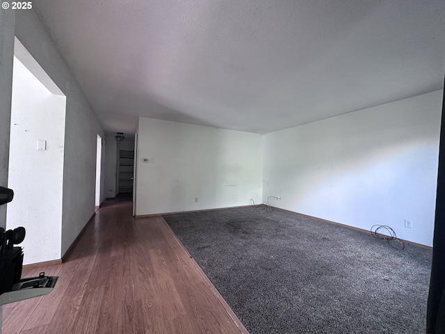 unfurnished room featuring baseboards and dark wood finished floors