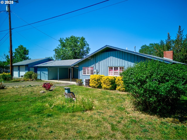 3034 Fisher Rd, Roseburg, OR 97471 - rear view of house with board and batten siding, a yard, central air condition unit, and a carport