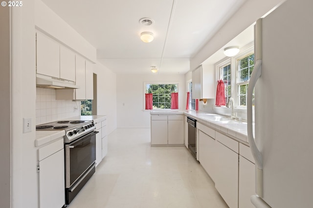 3034 Fisher Rd, Roseburg, OR 97471 - kitchen with freestanding refrigerator, electric range, under cabinet range hood, dishwashing machine, and backsplash