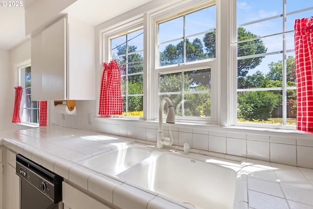 3034 Fisher Rd, Roseburg, OR 97471 - kitchen with dishwashing machine, a sink, white cabinets, and healthy amount of natural light