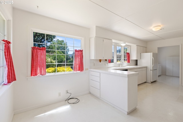 3034 Fisher Rd, Roseburg, OR 97471 - kitchen featuring freestanding refrigerator, white cabinetry, light countertops, a peninsula, and a sink