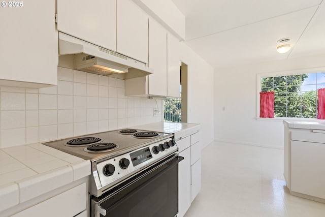 3034 Fisher Rd, Roseburg, OR 97471 - kitchen with electric range, under cabinet range hood, backsplash, tile counters, and white cabinetry