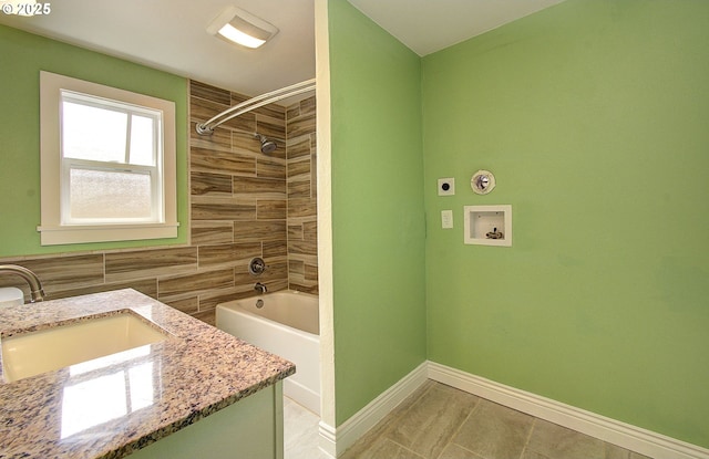 bathroom featuring vanity, baseboards, and shower / washtub combination