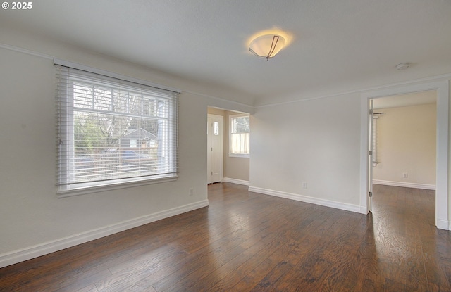 unfurnished room with dark wood finished floors and baseboards