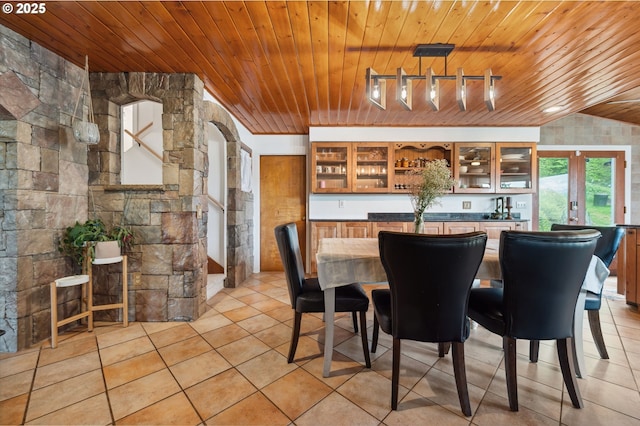 dining room with indoor bar, track lighting, and wood ceiling