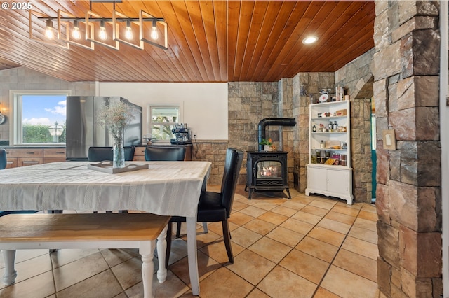 tiled dining room featuring a wood stove and wood ceiling