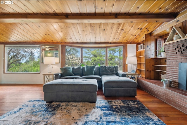 living room featuring lofted ceiling with beams, wood-type flooring, and a brick fireplace