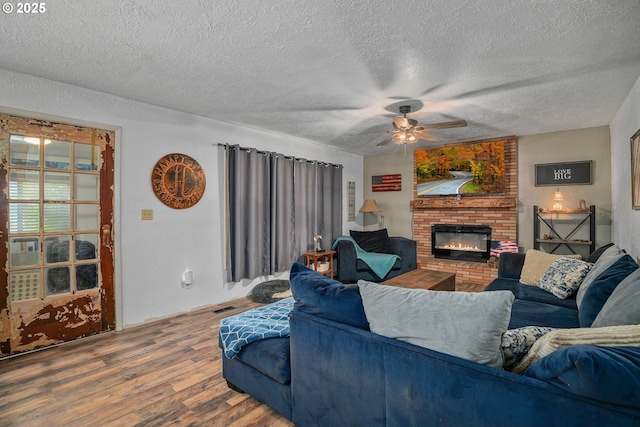 4435 Hazelgreen Rd NE, Salem, OR 97305 - living room with wood finished floors, a fireplace, ceiling fan, and a textured ceiling