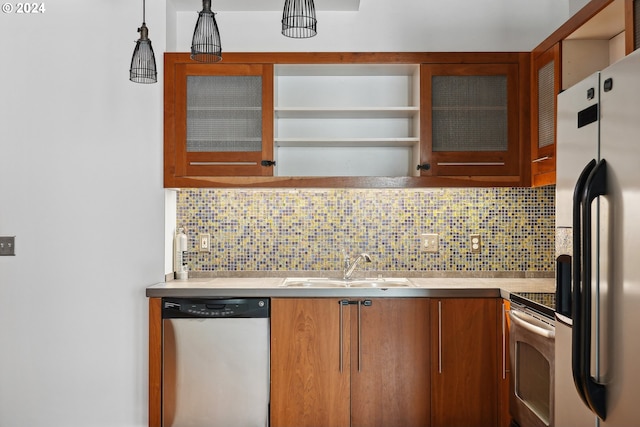 kitchen with decorative light fixtures, sink, stainless steel appliances, and decorative backsplash