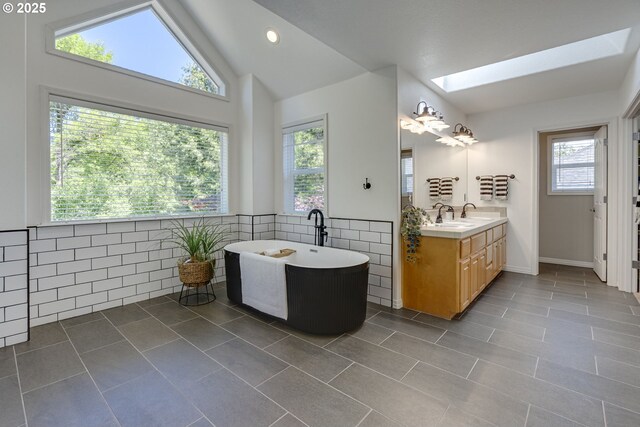 3011 Sabo Ln, West Linn, OR 97068 - bathroom with a skylight, vanity, a freestanding tub, tile patterned flooring, and lofted ceiling