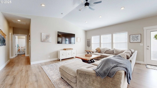 living area featuring a ceiling fan, light wood-type flooring, vaulted ceiling, and baseboards