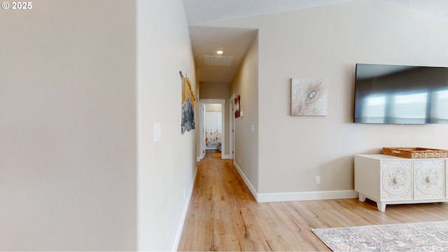 corridor with wood finished floors, visible vents, and baseboards