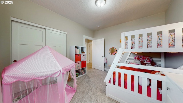 bedroom with light carpet, a closet, and a textured ceiling