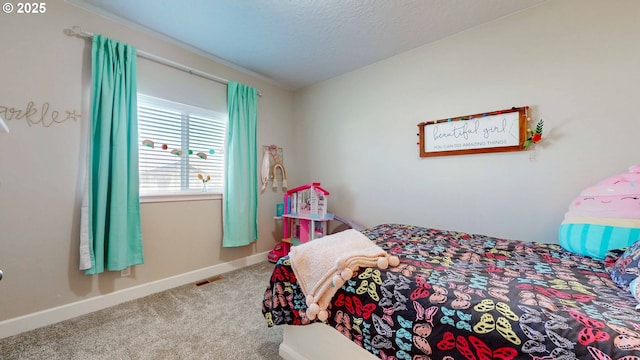 carpeted bedroom with baseboards, visible vents, and a textured ceiling